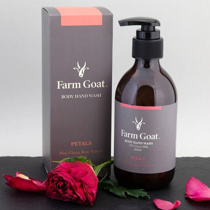 Farm goat body and hand wash sitting next to packaging with rose petals