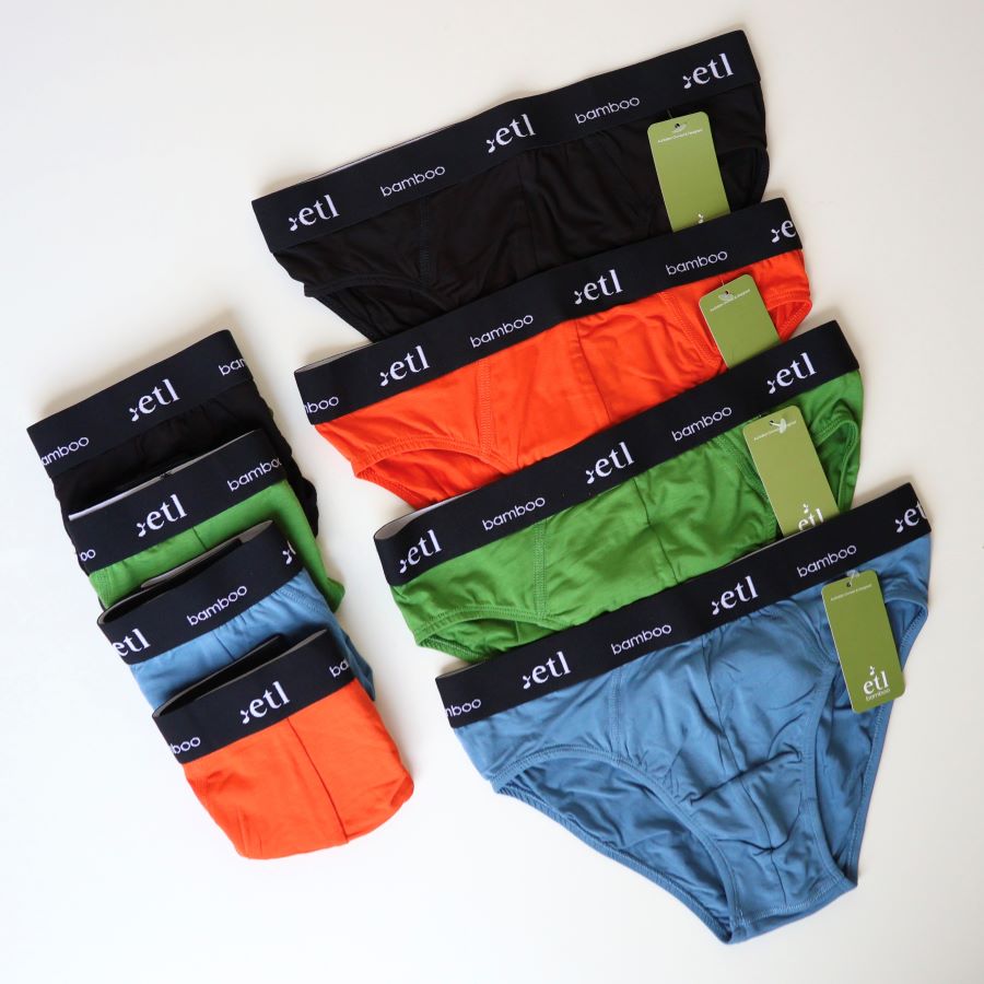 Mens bamboo briefs on table. Colours black, orange, green and blue laid out in a line