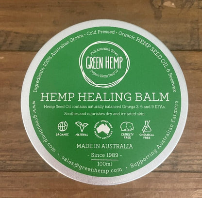 Hemp healing balm tin with green lid sitting on table