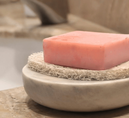 Soap Riser on soap dish with bar of soap on top on bathroom bench